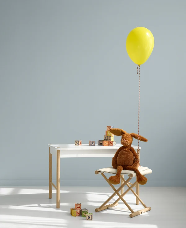 Ambiente infantil Oliver Furniture com mesa, coelho de peluche e balão amarelo